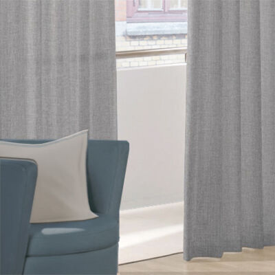 Grey curtains AIR behind an armchair