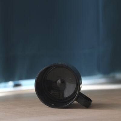 Unbreakable coffe mug with ear lies on the floor