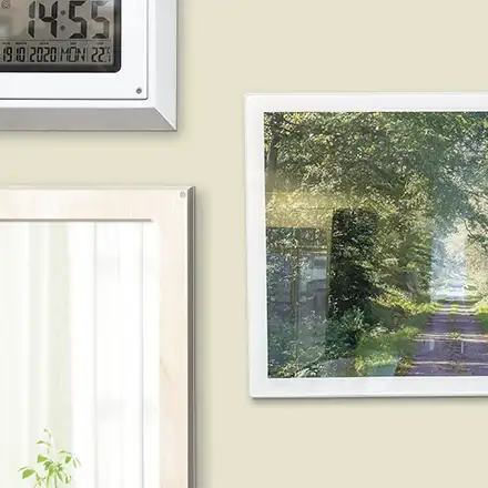 Uhr, Spiegel und ein Foto einer Waldstraße an einer Wand